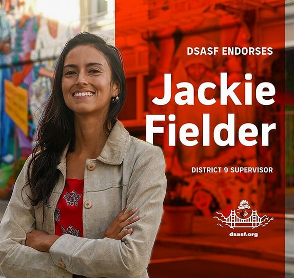An image that shows Jackie Fielder posing in front of murals in the Mission and smiling. The text on the image reads, "DSA SF endorses Jackie Fielder, District 9 Supervisor."