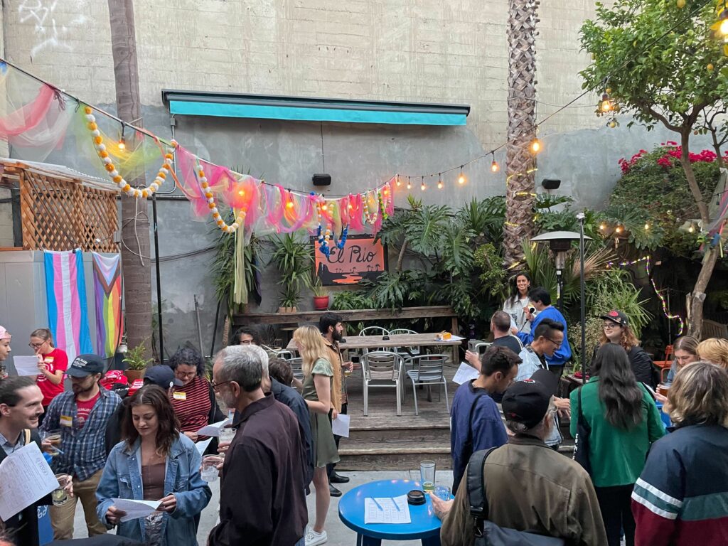 A photo of about two dozen people socializing on El Rio's outdoor patio.